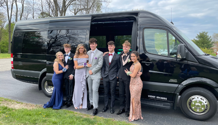 prom dates standing in from of party bus